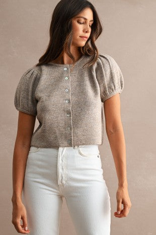 Full front view of a women's button down knit sweater featuring a crew neck, full-length button front placket, short puff sleeves, relaxed silhouette, and soft stretchy knit fabric.