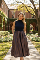 Women's casual striped midi dress styled with sneakers for an elevated everyday outfit, featuring a sleeveless mock neck top, vertical striped skirt, relaxed silhouette, and side pockets