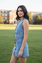 Washed denim two-piece set from Thread Bar Boutique featuring a sleeveless vest top, button-front closure, and matching mini skirt with scalloped hem. Trendy boutique outfit for casual summer days and elevated everyday fashion.