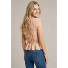Lightweight women's peplum knit top featuring shirred detailing, cap sleeves, round neckline, and button-back closure.