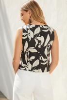 Women's black and cream botanical print midi skirt set with a cropped sleeveless top, perfect for resort vacations, beach dinners, and summer occasions.