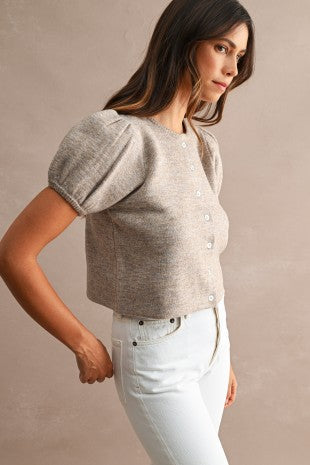 Close-up of women's short puff sleeve knit sweater showing structured puff sleeves, crew neckline, textured knit fabric, and polished button front detailing.