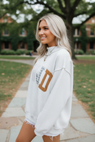 Full-front view of a women's WWJD faith-based graphic sweatshirt with embroidered lettering and mixed floral, plaid, and vertical stripe patches, styled as a casual Christian outfit.