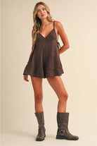 Women’s chocolate brown textured romper featuring adjustable tie-side waist details, V-neckline, and flared shorts