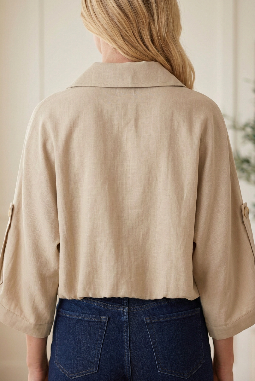 Back view of taupe lightweight utility jacket with a folded collar, wide 3/4 sleeves and gathered hem