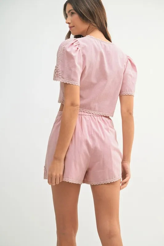 Two-piece outfit featuring a crochet lace crop top and matching high-waisted shorts, styled for a soft and feminine summer look.

