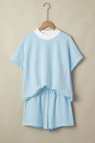 Blue and white striped outfit on a hanger against a beige background