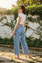 Sky blue polka dot wide-leg jeans back view showing cream dot print on light wash denim, back patch pockets and elastic waistband detail