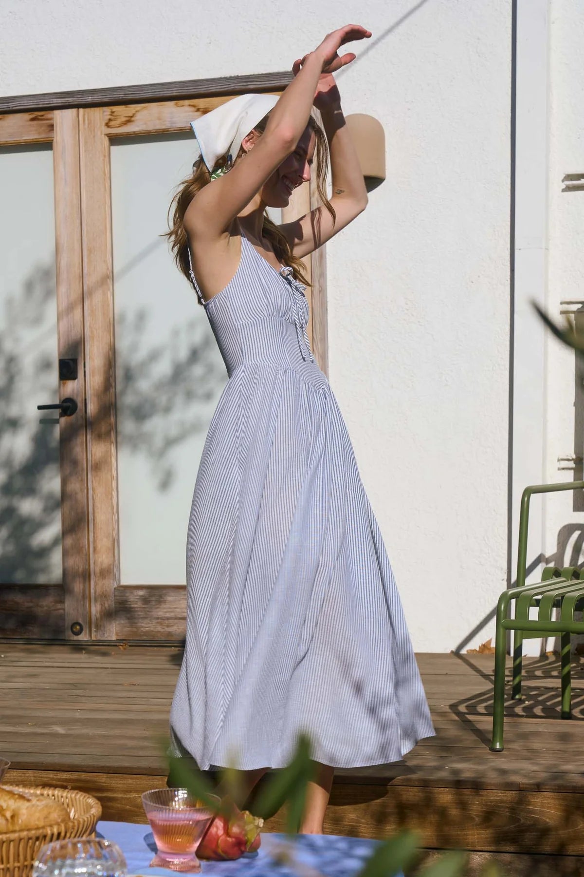 A coastal chic fashion staple, this sleeveless striped dress is made from a lightweight, breathable fabric. The image captures the crisp texture of the taupe stripes and the structured yet airy drape of the A-line summer dress silhouette blue