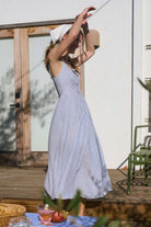 A coastal chic fashion staple, this sleeveless striped dress is made from a lightweight, breathable fabric. The image captures the crisp texture of the taupe stripes and the structured yet airy drape of the A-line summer dress silhouette blue