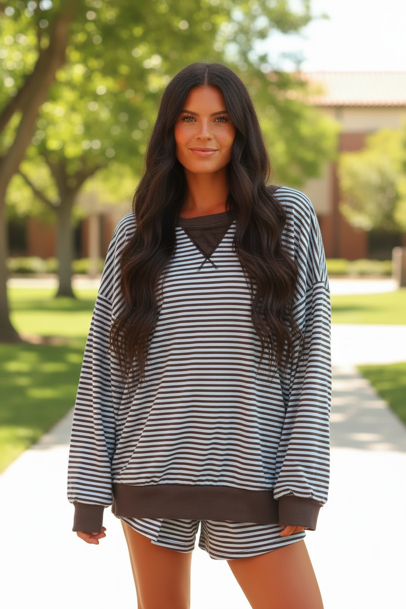Dark brunette model wearing brown stripe oversized long sleeve top and matching drawstring shorts - upper body shot showing oversized silhouette outdoors