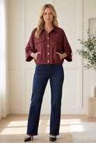 Entro burgundy lightweight utility jacket with button front, flap chest pockets and elastic hem, styled with dark jeans.