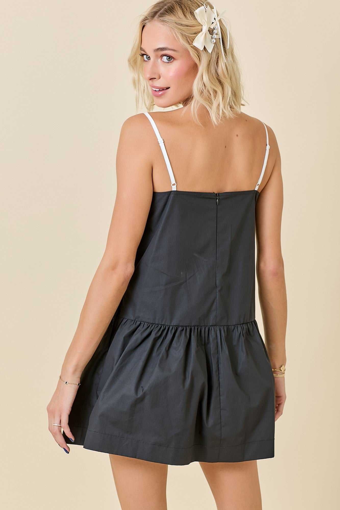 Black and white drop-waist mini dress featuring contrast knotted edge detailing, a sporty silhouette, and a relaxed fit — perfect for game day or casual chic styling.