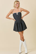 Black and white drop-waist mini dress featuring contrast knotted edge detailing, a sporty silhouette, and a relaxed fit — perfect for game day or casual chic styling.