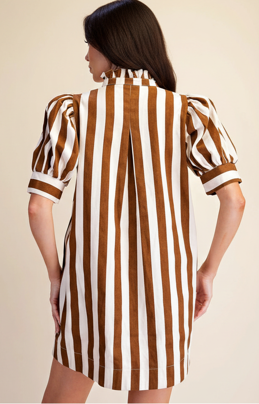 A woman shown from the back wearing a brown and white vertically striped dress with puff sleeves and a ruffled high neck, against a plain beige studio background.