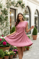 pink sleeveless mini dress with side cutouts, ruched waist detail, and flared skirt