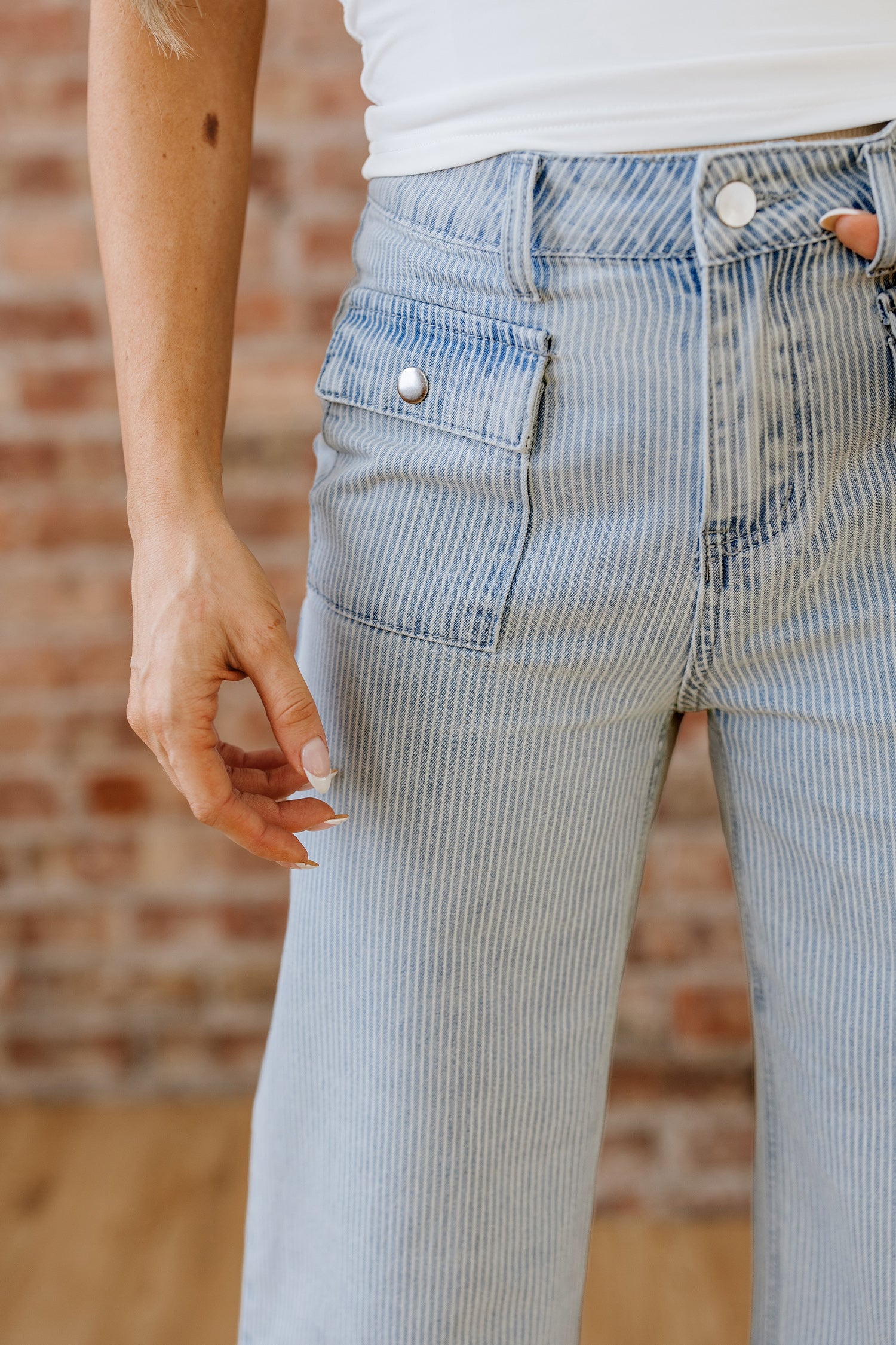 Wide leg light blue jeans with pinstripe detail and button flap pockets