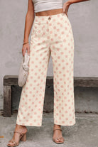 High-waisted cream pants with bold polka dot print, wide-leg silhouette, and zipper button front closure