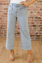 Light wash denim jeans with subtle stripe pattern and rolled cuff hem