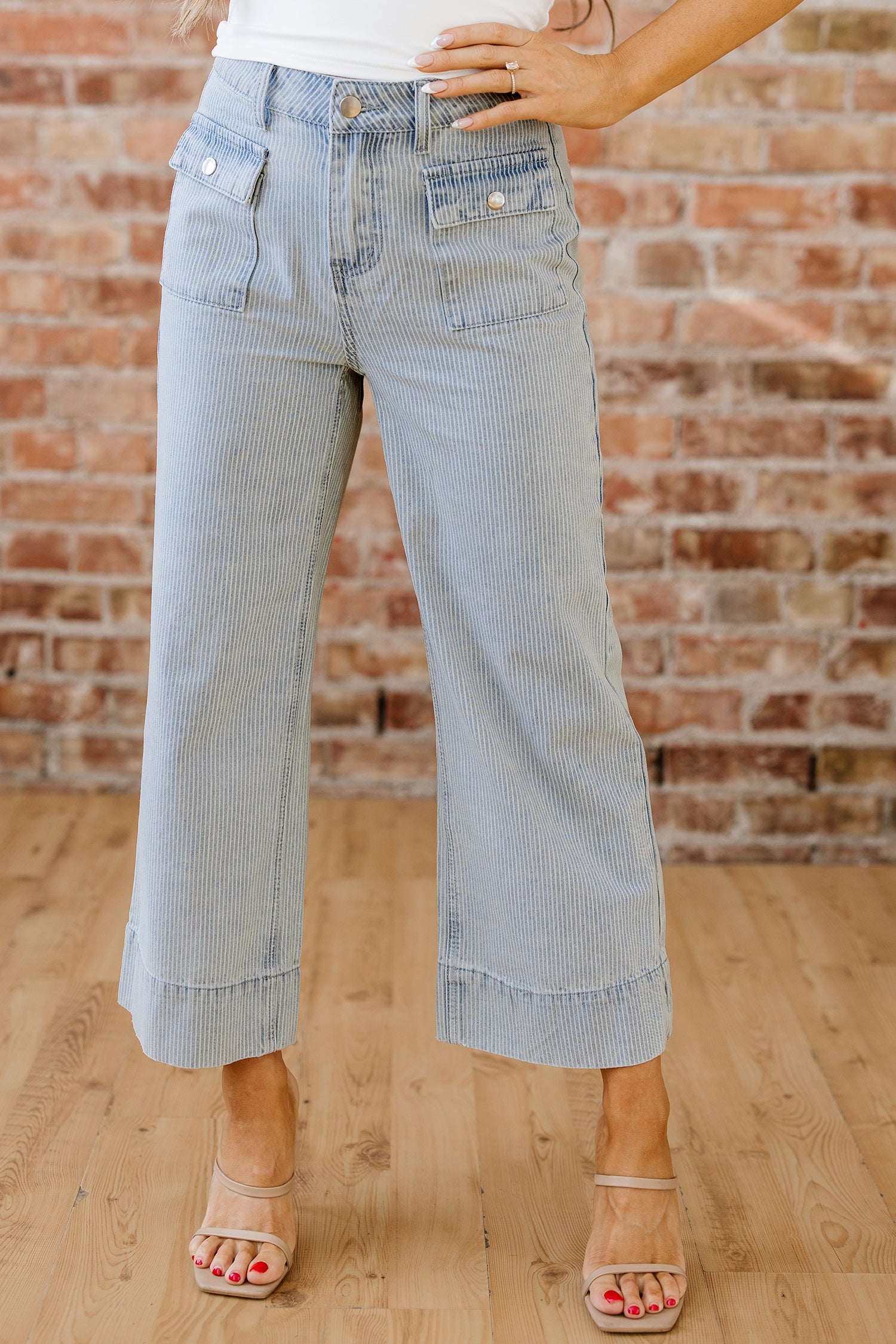 Light wash denim jeans with subtle stripe pattern and rolled cuff hem