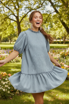 Light wash denim A-line mini dress with tiered skirt and puff sleeves from Thread Bar Boutique