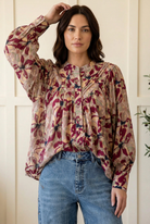 Floral blouse raised-arm pose showing balloon sleeves