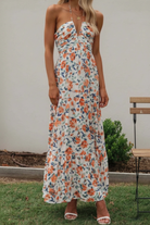 Floral halter midi dress from Thread Bar Boutique featuring ruched front, open tie back, and flowy feminine silhouette