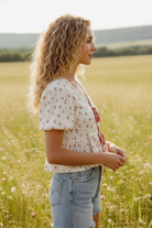 Airy floral gauze blouse with adjustable front ties, soft cotton fabric, and a loose, flattering silhouette for everyday wear