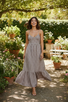 Sleeveless gingham maxi dress with adjustable spaghetti straps and flowy tiered silhouette, perfect for warm weather outings