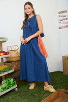woman wearing a denim set top is pleated with ties and skirt is maxi length with pockets