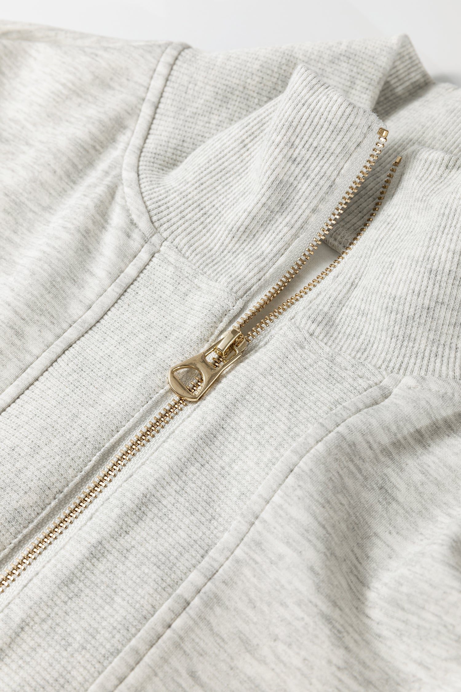 Detail shot of zipper collar and fabric texture on light grey two piece set