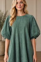 Half body detail shot of the bubble sleeves, round neck, and corduroy texture