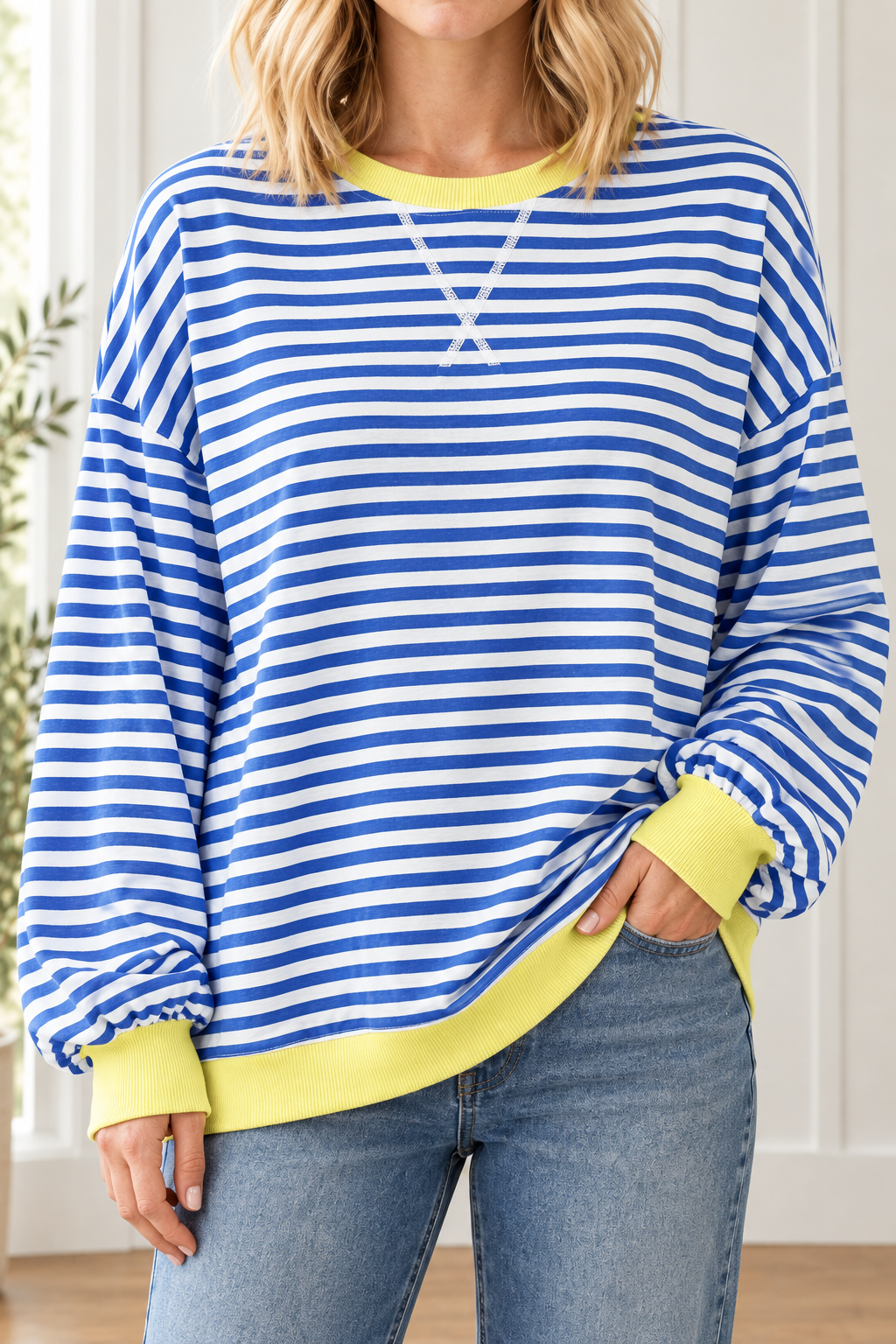 Close-up of blue and white striped pullover highlighting white front V stitching, yellow ribbed neckline and cuffs.