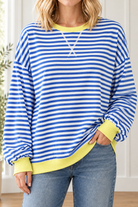 Close-up of blue and white striped pullover highlighting white front V stitching, yellow ribbed neckline and cuffs.