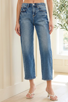 Angled front view of RISEN cropped barrel jeans showing the roomy leg shape, high waist and blue denim fading.