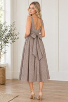 Back view of brown and cream gingham midi dress showing open scoop back and waist level self tie bow