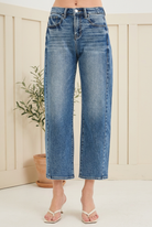 Front view of RISEN high rise cropped barrel jeans with faded blue denim, curved front pockets and finished hems.