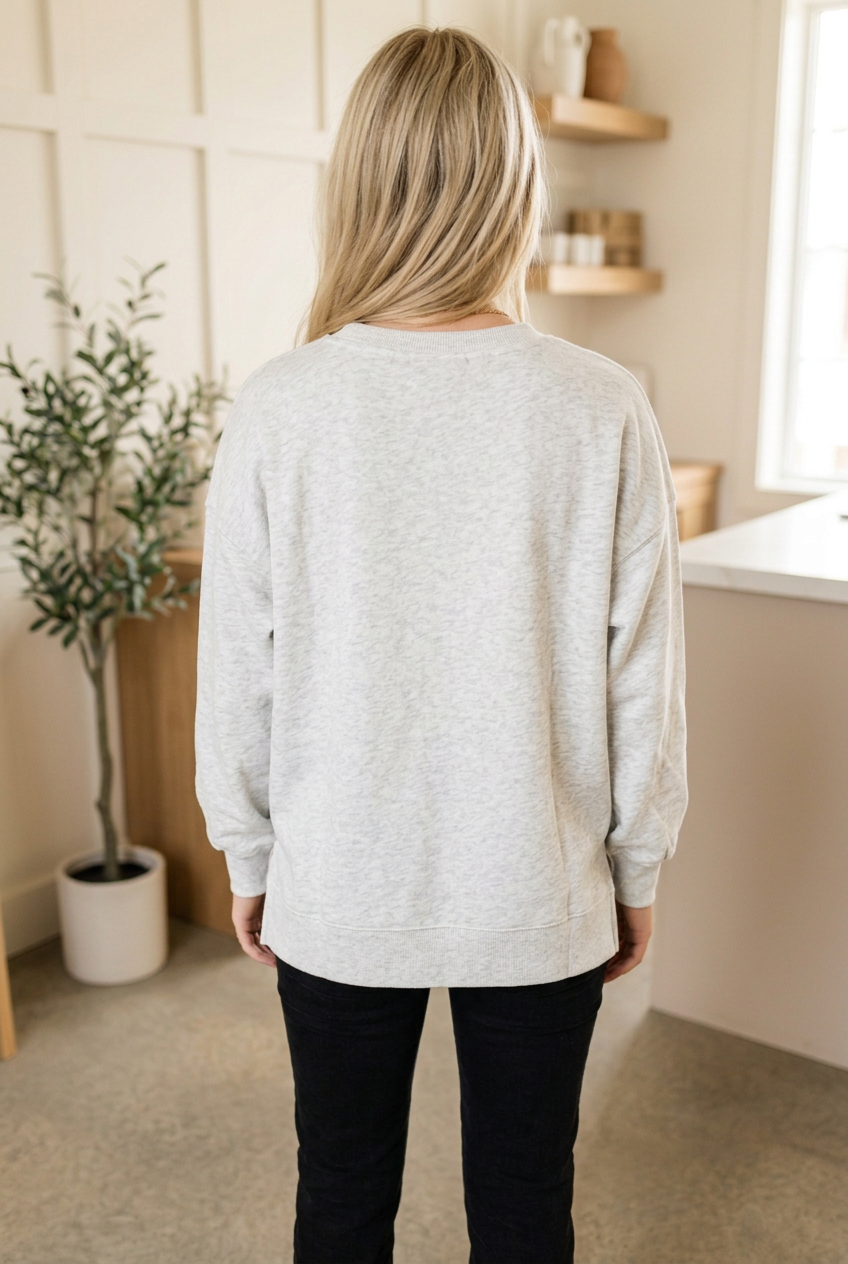 Back view of light grey Christmas sweatshirt showing a plain back, relaxed silhouette, dropped shoulders and long sleeves.