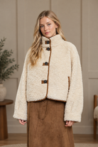 Ivory sherpa button down jacket with mock neck and brown suede trim from Thread Bar Boutique