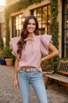 Women's red stripe oversized ruffle sleeve blouse full body front view, hand on hip, lightweight twill top styled with light wash jeans