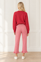 Back view of red and white gingham pants showing the high waistband, center back seam, straight cropped legs and matching ruffle hems.