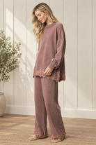 Mauve-brown French terry track pants with wide legs and floral lace hems, worn with the coordinating sweatshirt.