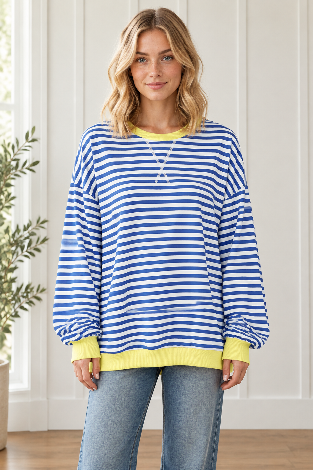 Front view of women's oversized blue and white striped pullover with yellow crew neckline, cuffs and hem.