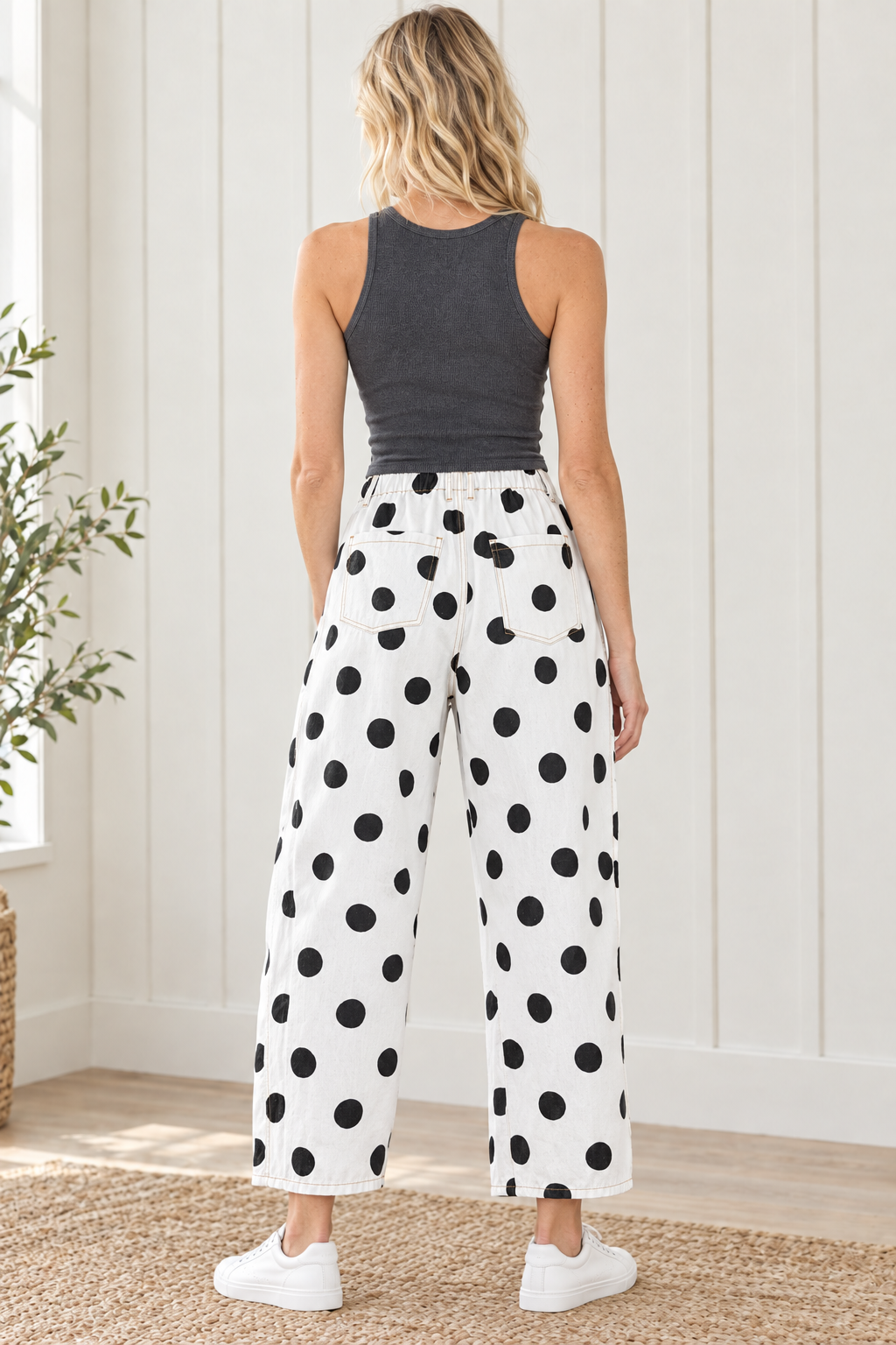 Back view of white black polka dot jeans showing gathered waistband, two patch pockets and cropped hems