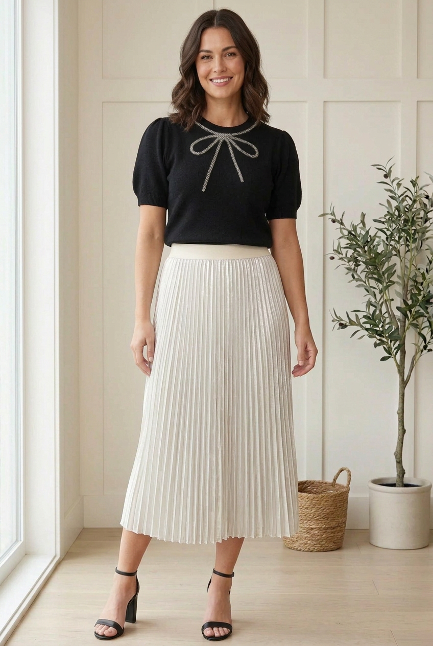 Front view of black sweater top with a silver beaded bow, embellished crew neckline and puffed half sleeves.