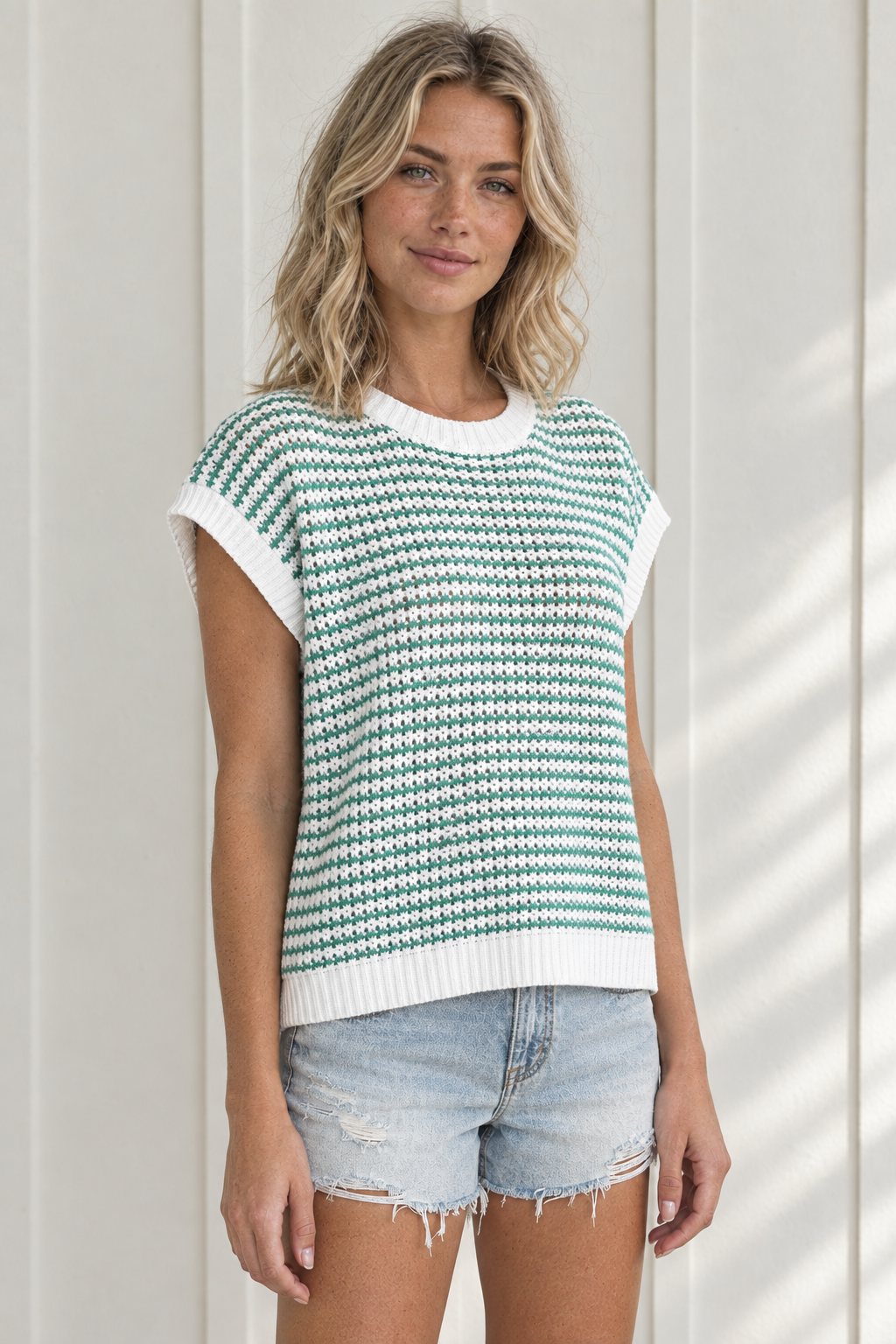Three-quarter front view of Coastal Stripe Knit Tank with green and white knit stripes and broad sleeveless shoulders
