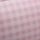 Close-up of baby pink gingham embossed faux leather fabric texture