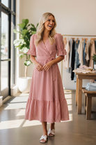 Red and white stripe tiered wrap midi dress with puff sleeves and V-neckline, candid lifestyle fashion photo with white sandals, women's boutique dress available at Thread Bar Boutique