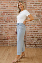 Sky blue pinstripe wide leg jeans side view — Eve relaxed fit denim with rolled cuff hem and brick wall background