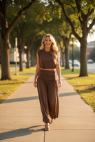 Brown sleeveless bubble crop top and flowing ruched waistband maxi skirt, blonde model walking and laughing on tree-lined campus sidewalk, golden hour light, versatile two-piece set